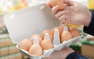 mujer comprando huevos en el supermarcado